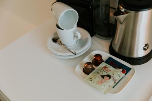 a cup and saucer with a book on a counter at Hotel Jerom in Kalmthout