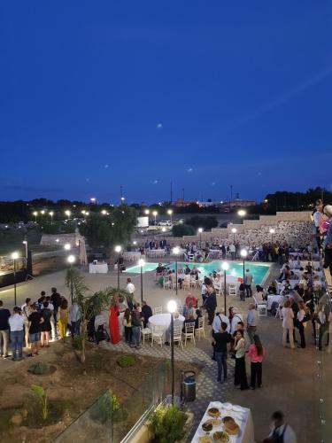 a crowd of people standing around a party at night at Agriturismo Tenuta Don Giovanni in Melendugno