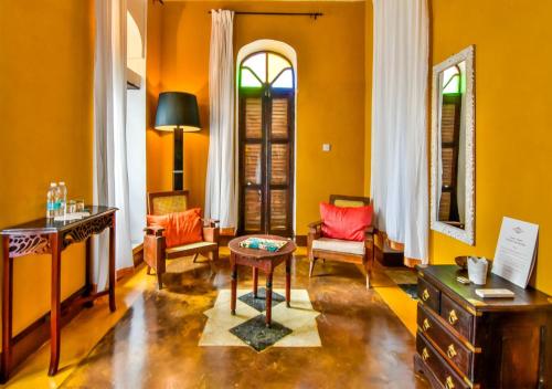 - un salon avec des murs orange, une table et des chaises dans l'établissement Kholle House, à Zanzibar City
