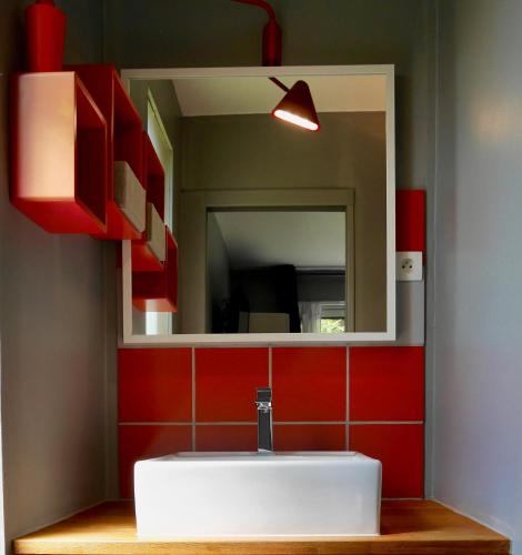une salle de bain avec un lavabo blanc et un miroir dans l'établissement Les Cabanes de Do, au Mans