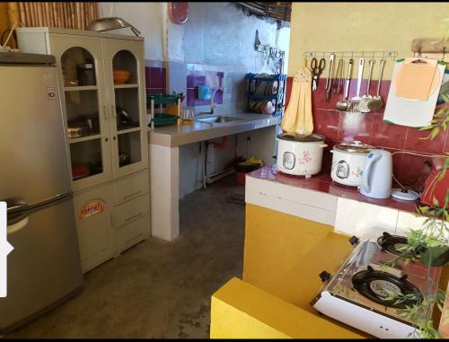 a kitchen with a refrigerator and a counter top at Carribean Transient House in Lucap