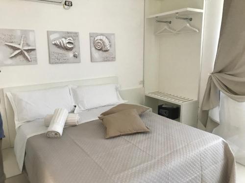 a white bedroom with a bed with towels on it at Villa Vittoria City in Rodi Garganico