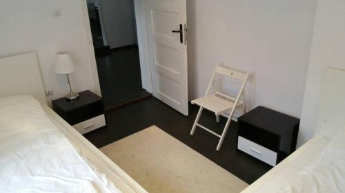a bedroom with a bed and a chair and a door at Smart and Cozy Nature House in Belogradchik