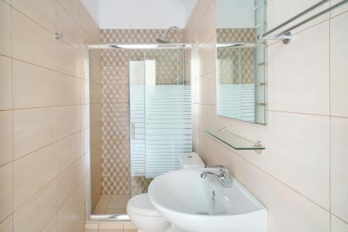 a bathroom with a sink and a toilet and a mirror at Villa Karydies in Limenas