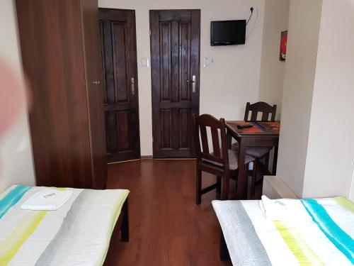 a room with two beds and a table with a desk at Marcus in Bydgoszcz