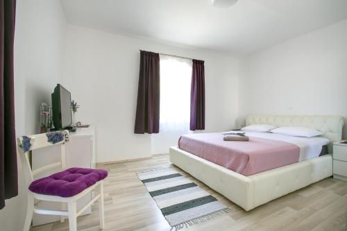 ein Schlafzimmer mit einem großen Bett und einem Stuhl in der Unterkunft Apartment Maja in Pula