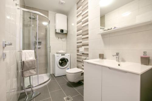 ein Badezimmer mit einem Waschbecken und einer Waschmaschine in der Unterkunft Apartment Maja in Pula