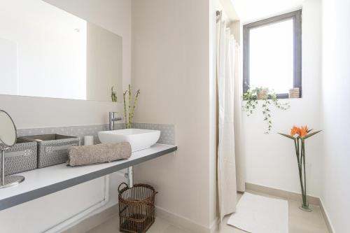 a white bathroom with a sink and a window at Domaine Sesquier Mas d'exception Belle de Nuit in Mèze