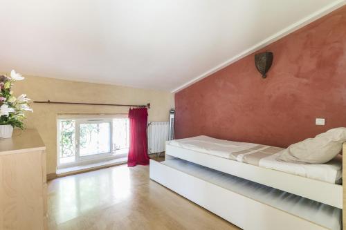 1 dormitorio con cama y pared roja en Domaine Sesquier Mas d'exception Acacia en Mèze