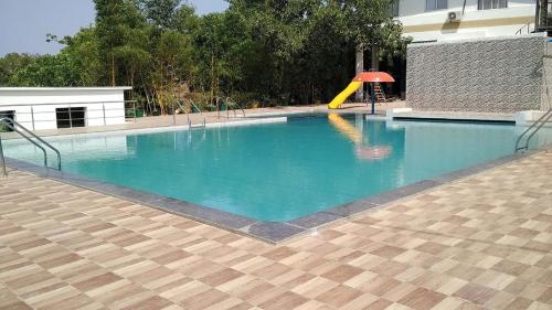 a swimming pool with a slide and a playground at Rainforest Resort and Spa, Igatpuri -Nature's Luxury Awaits in Igatpuri