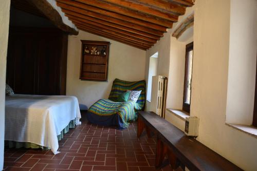 una camera con un letto e una sedia e una finestra di Piccozzo agritour a Casciana Terme