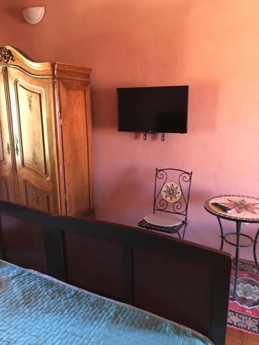 a bedroom with a bed and a tv on a wall at Hill House Marija in Komiža