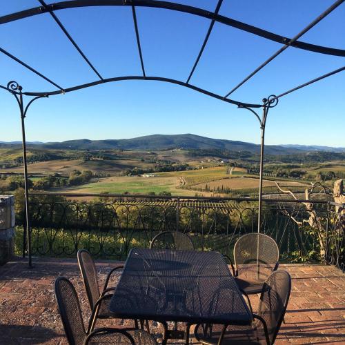 a table and chairs on a patio with a view at Residenza Cornino in Castellina in Chianti
