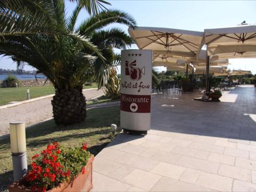 a sign for a restaurant with a palm tree at Hotel Saraceno Al Faro in Taranto