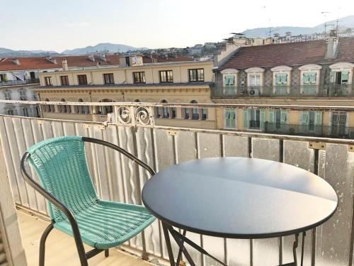 una mesa y una silla en un balcón con vistas en Notre Dame en Niza
