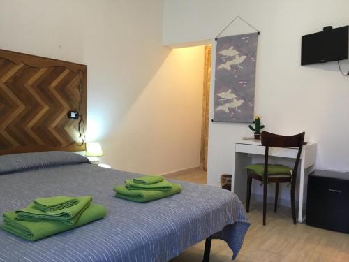 a bedroom with a bed with green towels on it at b&b Franzisca in Torpè