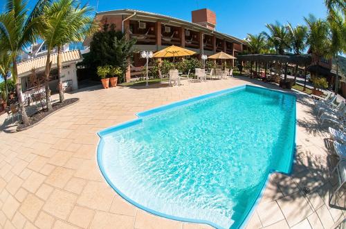 a large swimming pool in front of a hotel at Pousada Ponta do Lobo in Balneário Camboriú