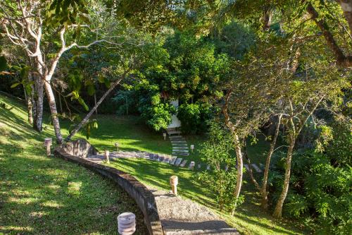 a garden with trees and a building in the distance at Pousada Ponta do Lobo in Balneário Camboriú
