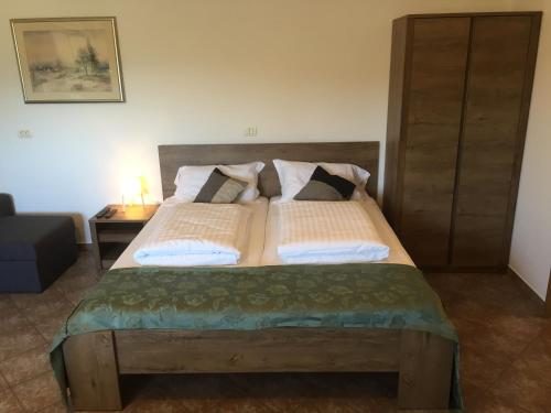 a bedroom with a large wooden bed with pillows at Apartma Valmarin in Spodnje Škofije