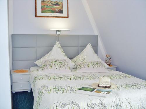 a bedroom with a white bed with a book on it at Willa Cyklada, grill, śniadania, jezioro,przystań,tawerna-200m, park linowy-400m, centrum,aquapark-900m in Mikołajki