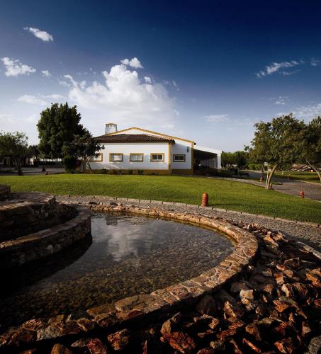 a fire hydrant in a pond in front of a house at Vila Gale Alentejo Vineyard - Clube de Campo in Albernoa