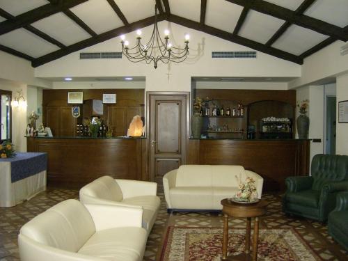 a waiting room with white chairs and a bar at La Locanda di Castromediano in Castelmezzano