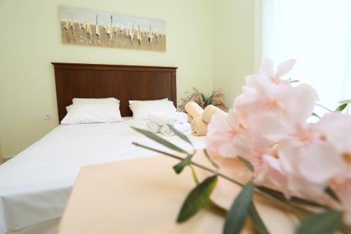 a bedroom with a bed with white sheets and pink flowers at Elia in Skála Foúrkas