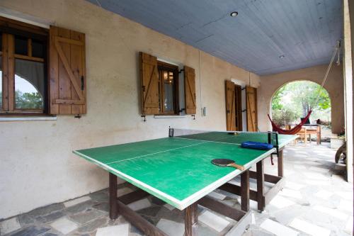 a ping pong table in the middle of a room at Mavilia Traditional Guesthouse in Ligourio