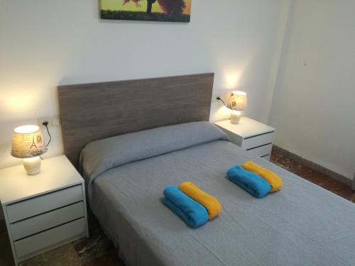 ロケタス・デ・マルにあるApartamentos Roquetas Playaのベッドルーム1室(ベッド1台に青と黄色の枕2つ付)