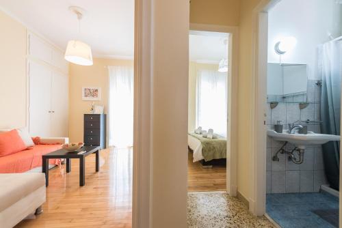 ein Wohnzimmer mit einem Sofa und einem Waschbecken in der Unterkunft Heart of the City in Athen