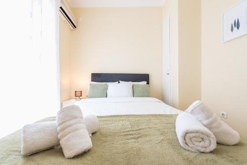 a bedroom with a large white bed with towels on the floor at Heart of the City in Athens