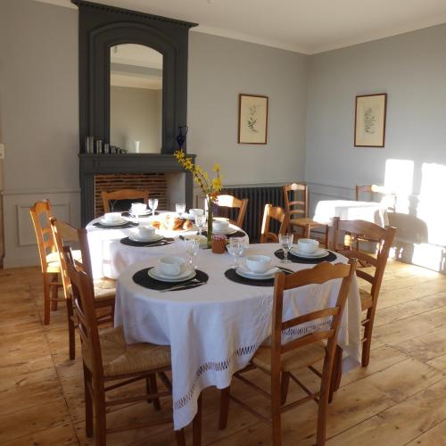 une salle à manger avec une table et un chiffon de table blanc dans l'établissement Chateau d'Annezay, à Annezay