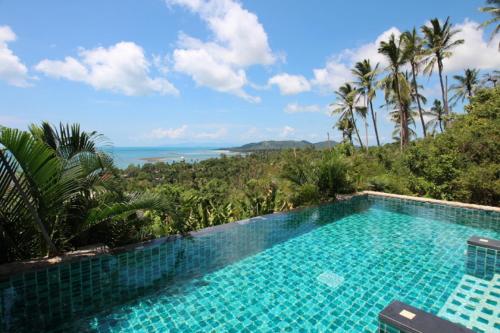 a swimming pool with a view of the ocean at Tropical Sea View Residence in Lamai