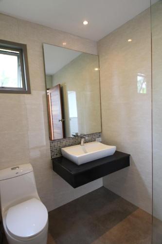 a bathroom with a toilet and a sink and a mirror at Tropical Sea View Residence in Lamai