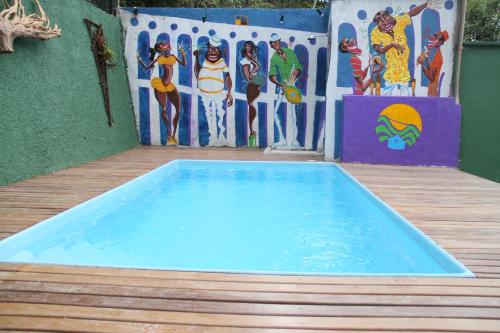 a swimming pool in front of a wall with a painting at Rio Forest Hostel in Rio de Janeiro