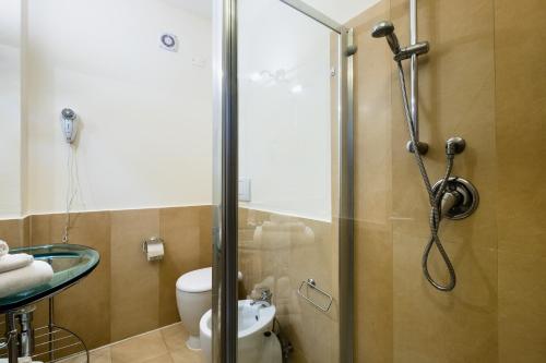a bathroom with a shower with a toilet and a sink at Canado Club Family Village in Marina di Castagneto Carducci