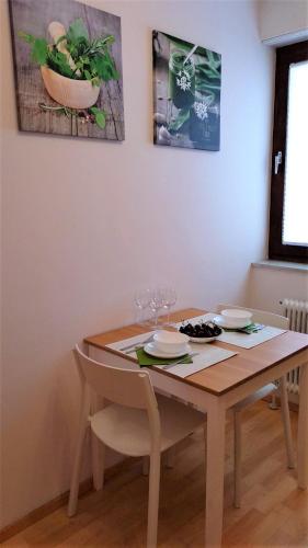 a wooden table with two plates and wine glasses on it at Green Wall Apartment Kaprun in Kaprun