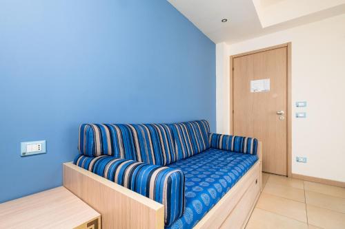 a couch in a room with a blue wall at Canado Club Family Village in Marina di Castagneto Carducci