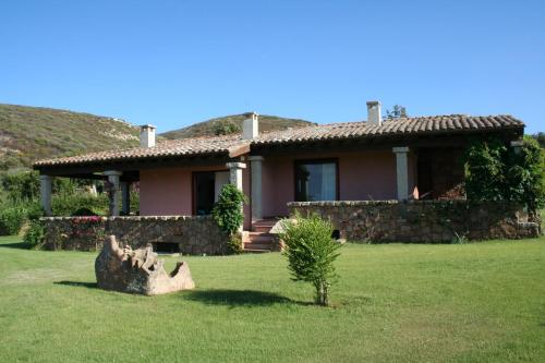 a house with a tree stump in front of it at Miriacheddu in San Teodoro