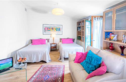 a living room with pink and blue pillows on a couch at Rita's Garden in San Vittore Olona