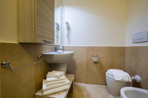 a bathroom with a sink and a toilet with towels at Canado Club Family Village in Marina di Castagneto Carducci