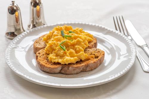 a white plate with a piece of bread with eggs on it at The Devonian in Douglas