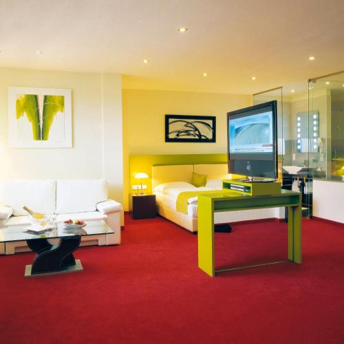 a bedroom with a bed and a tv and a couch at Hotel Restaurant Pusswald in Hartberg