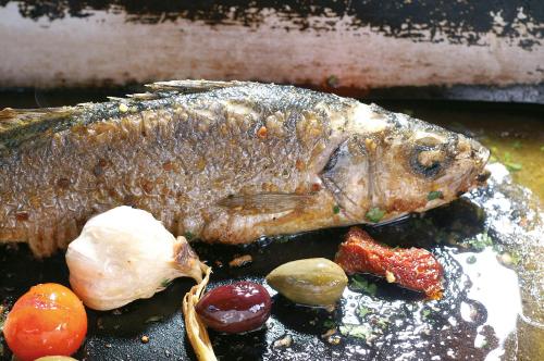 a fish sitting on a table with other foods at Hotel Restaurant Pusswald in Hartberg