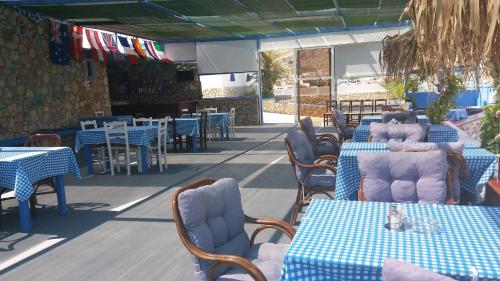 a restaurant with tables and chairs with a cat sitting on them at Kazonis Studios in Kalymnos