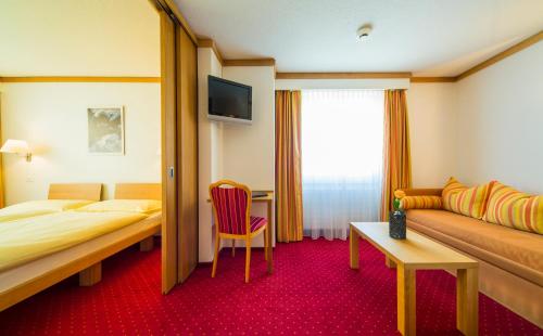 a hotel room with a bed and a couch at Hotel Excelsior in Zermatt