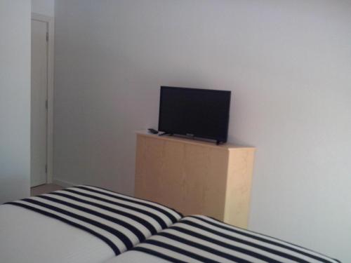 a bedroom with a bed and a television on a dresser at Nas Palhas Deitado in Fátima