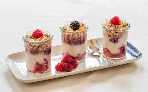 three jars of dessert on a plate with berries at The Devonian in Douglas