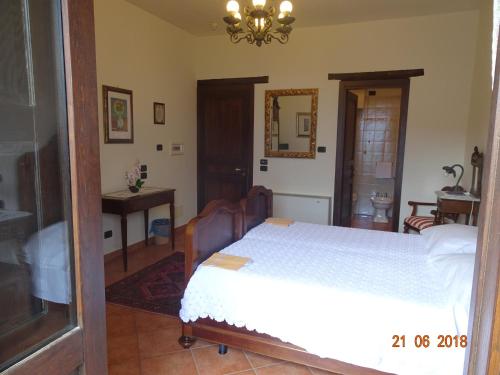 a bedroom with a white bed and a mirror at Castello di Altomonte in Altomonte