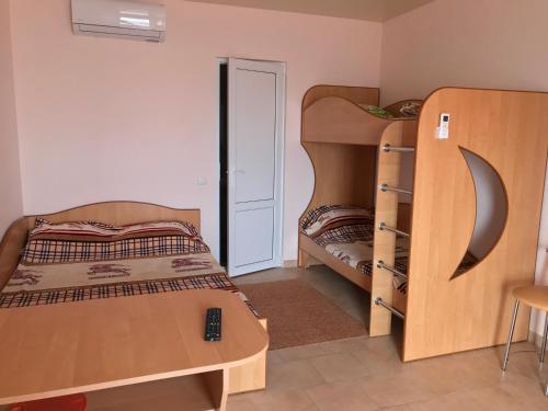 a bedroom with two bunk beds and a table at Mini-hotel Zefir in Zatoka